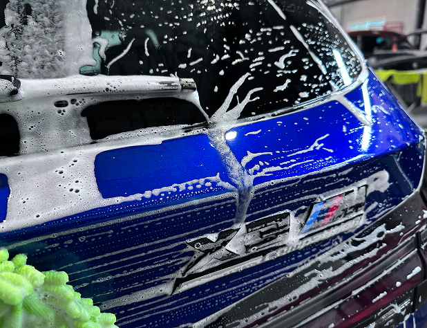 BMW X3M wordt ingefoamdt tijdens professionele autowasbeurt.